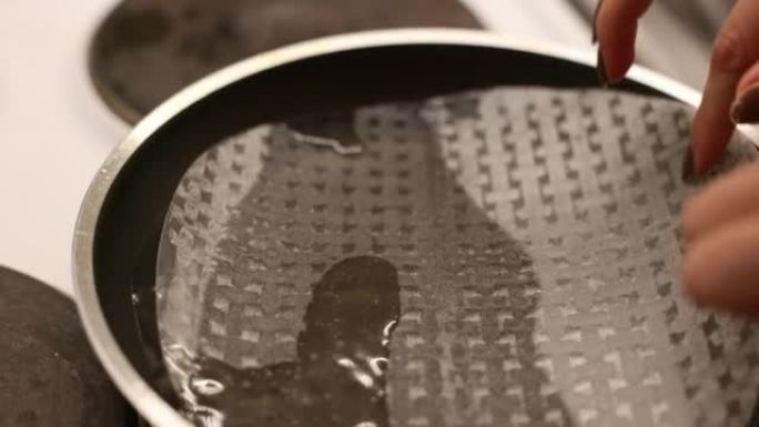 一个女人在锅里用水浸泡宣纸的特写镜头