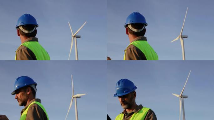 男性可再生能源工程师，从后面检查风塔。他转向摄像机