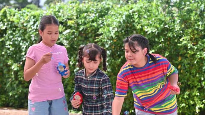 团体亚洲儿童女孩在操场春夏快乐吹肥皂