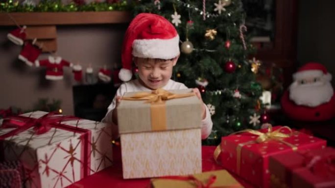 戴着圣诞老人帽子的年轻女孩正在打开她的圣诞礼物盒