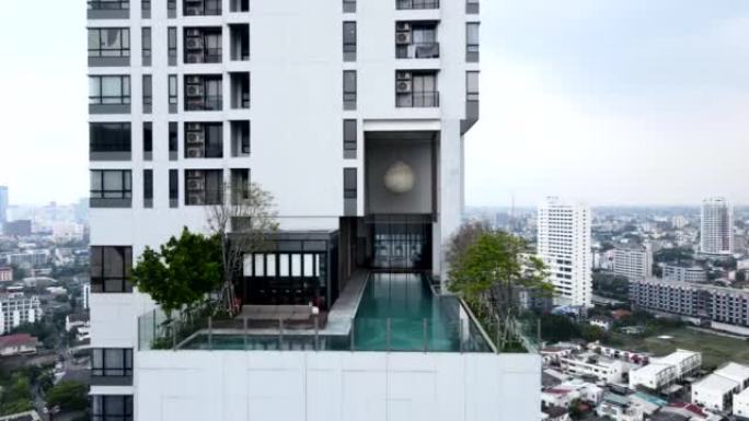 飞向泰国曼谷酒店屋顶的无边泳池。空中回撤镜头