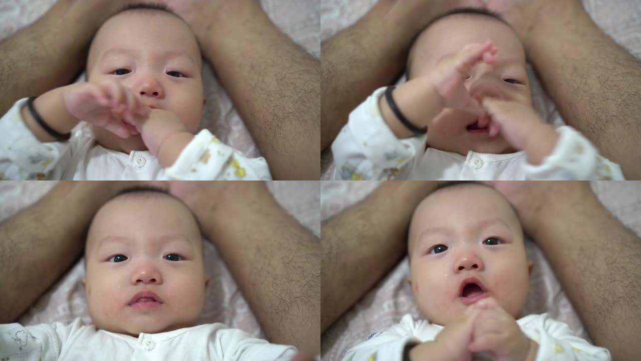 婴儿吮吸自己的手指整齐父亲的腿