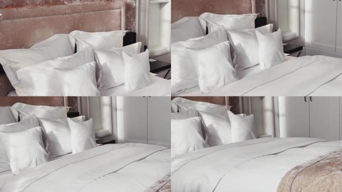 家居装饰和室内设计，豪华卧室配有白色床上用品的床，床单洗衣服务和家具细节