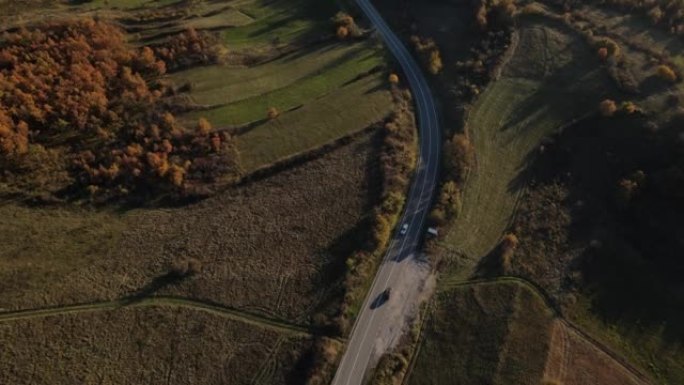 汽车在秋天驾驶空中无人机俯视图