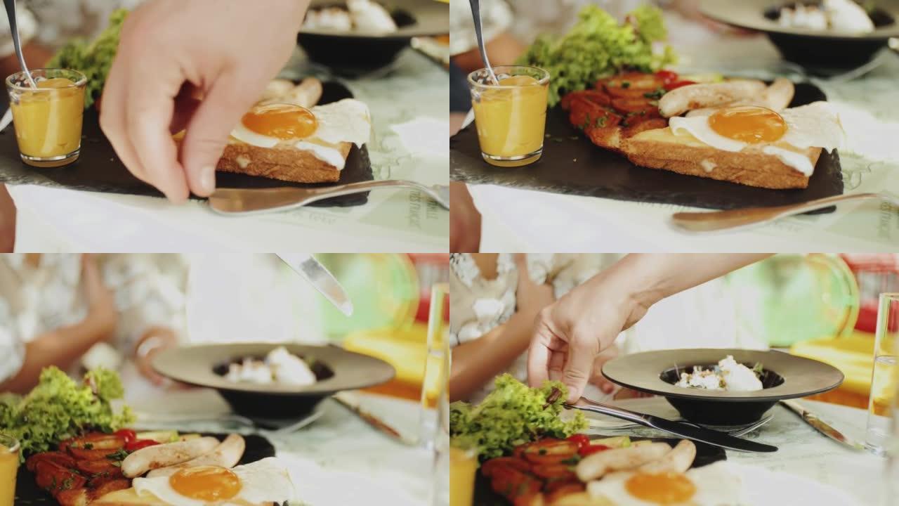 鸡蛋本尼迪克特在夏季咖啡馆，美式早餐，人手叉子，健康食品。