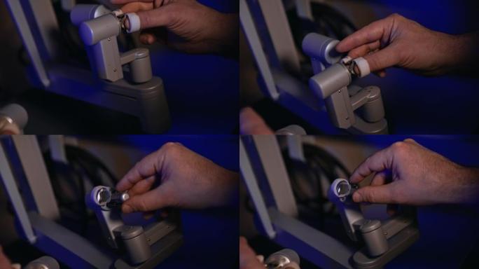 男性手在手术室移动机器人设备的灵敏旋转手柄。人工操作的手术机器人。特写。