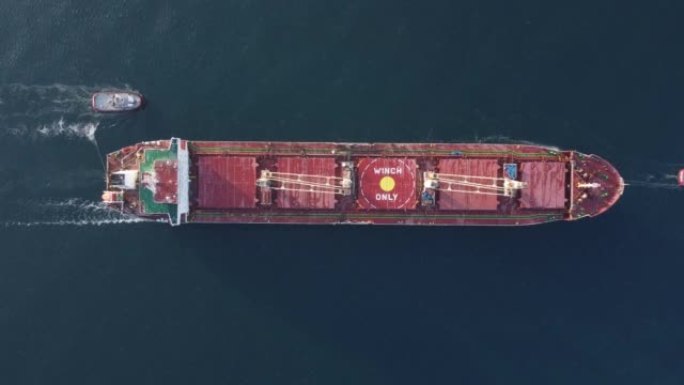 拖船辅助大型散货船的鸟瞰图。由拖船护送的大船。
