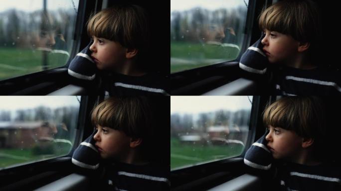 体贴的孩子盯着火车窗户感到悲伤。忧郁的乘客男孩在灰色的喜怒无常的日子里乘坐现代交通工具旅行