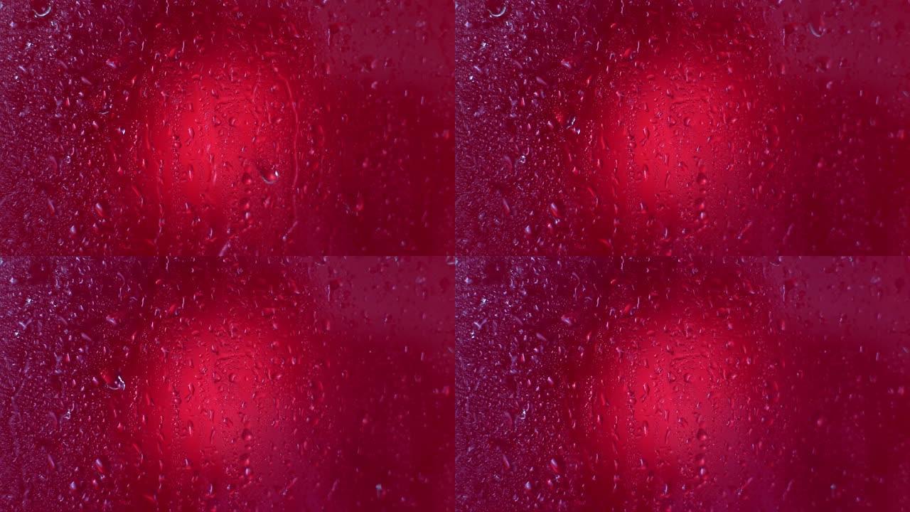 万岁洋红色背景上的水滴。雨滴落在玻璃窗上