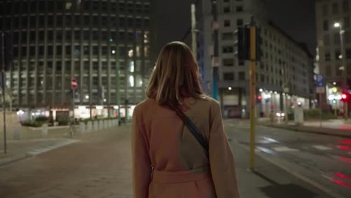 无法辨认的年轻白人妇女，晚上在米兰散步