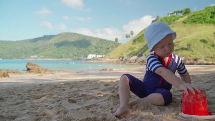 一个穿着泳衣的小男孩漫不经心地在热带海边玩耍。
