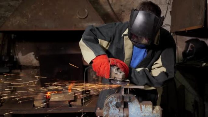 一名身穿制服的工人用研磨机切割金属，他戴着头盔和手套。