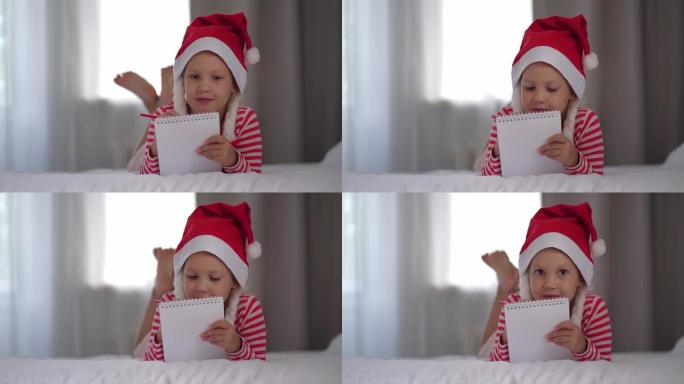 戴红色圣诞帽的女孩给圣诞老人写了一封信