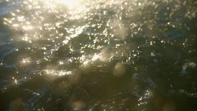 夏天的雨水落在海面上。太阳的光线反射到破碎的水面上。阳光普照时下雨。