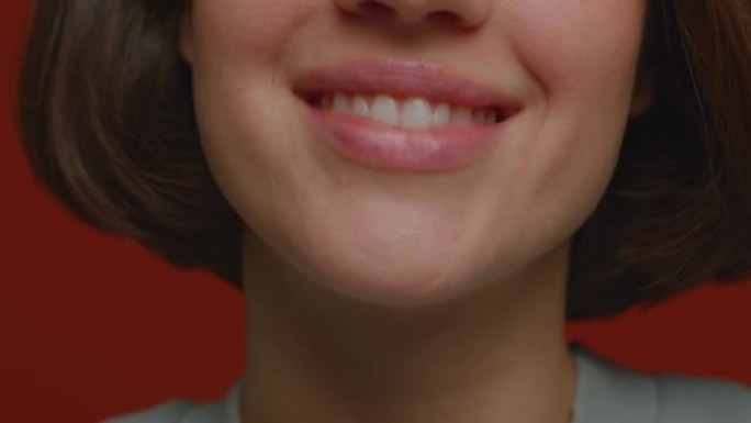 特写闪亮的女性微笑。快乐的女人在牙医诊所展示健康的白牙对牙科治疗感到满意