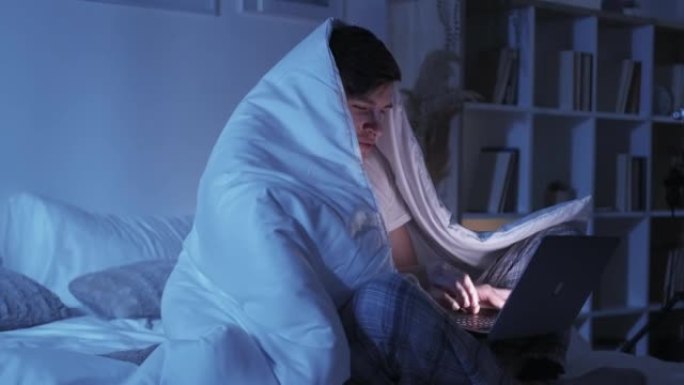 床上的夜间视频通话虚拟会议男笔记本电脑
