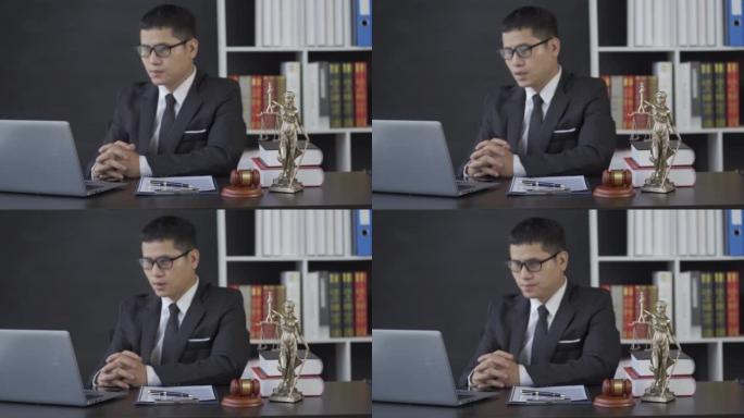 亚洲男性律师工作与锤子笔记本电脑正义女神在律师事务所，在线咨询的概念。
