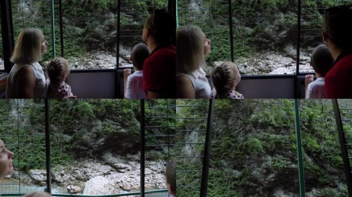 一家人乘坐小火车穿越关岛峡谷，看着河流