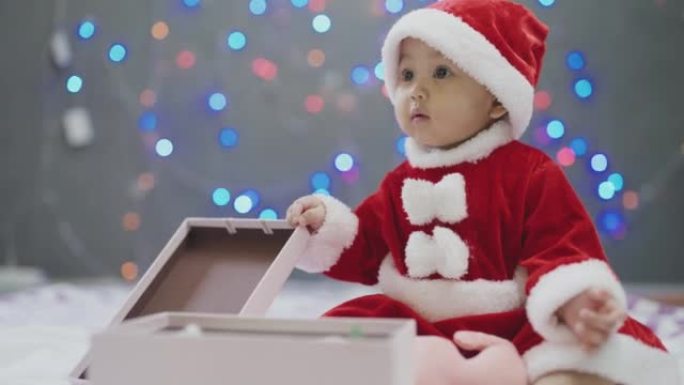 圣诞节在家带礼品盒的女婴。