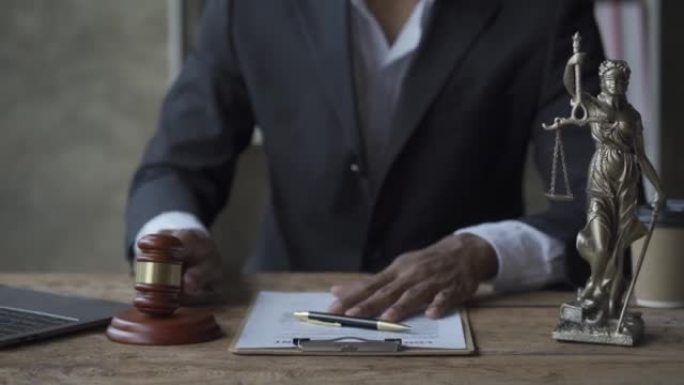 男性律师办公室与锤子和秤正义之神以及4k桌子上的三台笔记本电脑，智能手机和文件一起工作。