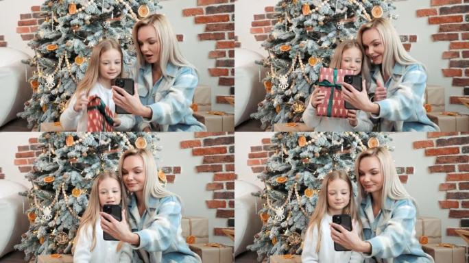幸福的母亲和女儿穿着便装在手机上进行视频通话，展示了圣诞树附近的朋友或亲戚，节日和通讯技术。新年。假