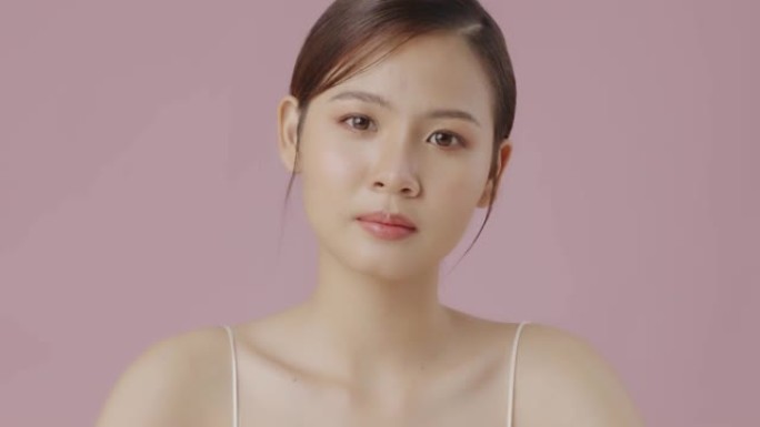 美丽的亚洲年轻女子肖像与光滑健康的皮肤睁开眼睛，美丽的年轻亚洲女子看着相机。