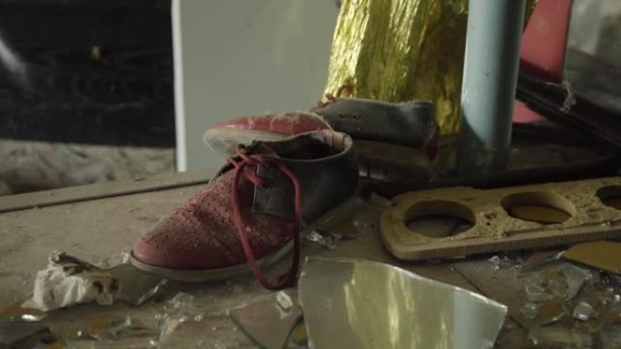 高清半毁建筑桌上的一双旧红鞋
