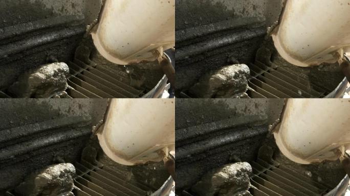 在施工现场的金属容器中从混凝土搅拌机中浇筑混凝土。