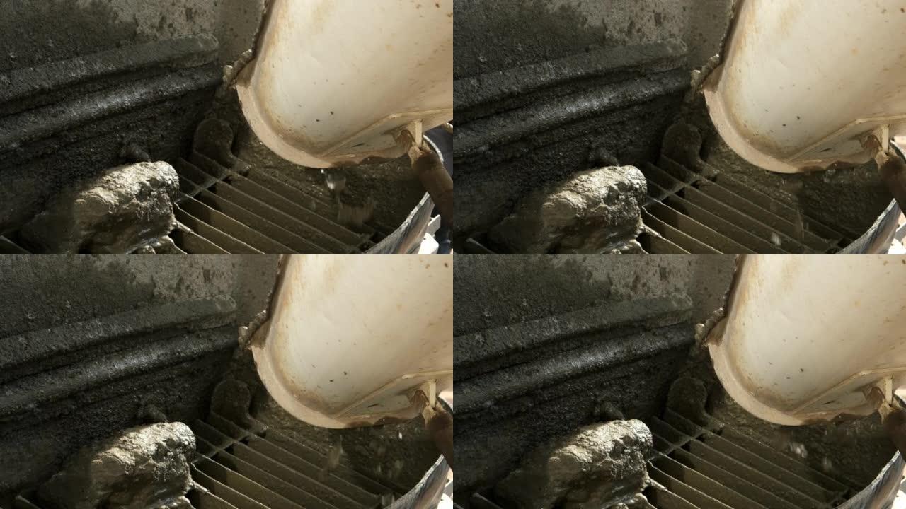在施工现场的金属容器中从混凝土搅拌机中浇筑混凝土。