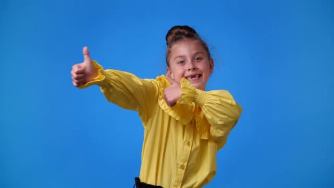 一个女孩在蓝色背景上竖起大拇指的4k慢动作视频。