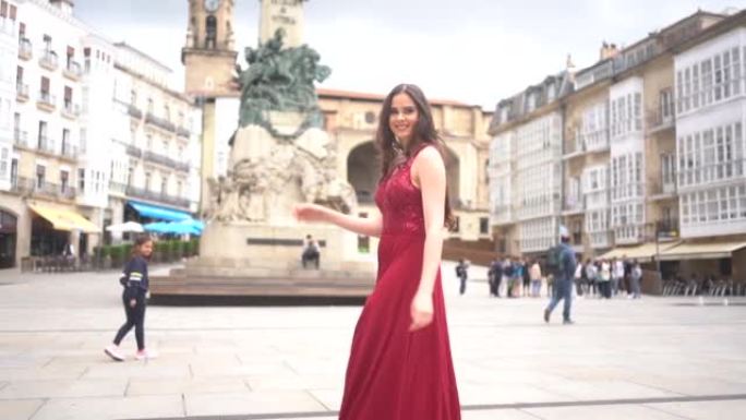 穿着红色连衣裙的高加索模特参观阿拉巴维多利亚市。西班牙