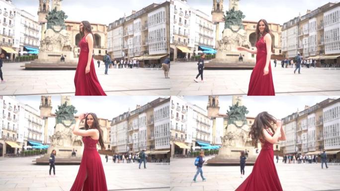 穿着红色连衣裙的高加索模特参观阿拉巴维多利亚市。西班牙