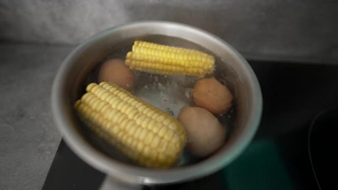 锅内煮沸的食物。用热水煮玉米和鸡蛋。营养食品