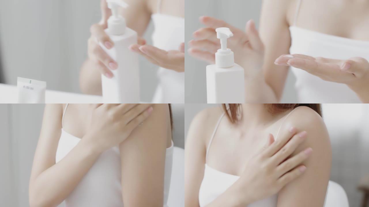 特写亚洲女性在肩膀上涂抹保湿面霜乳液。健康护肤理念。