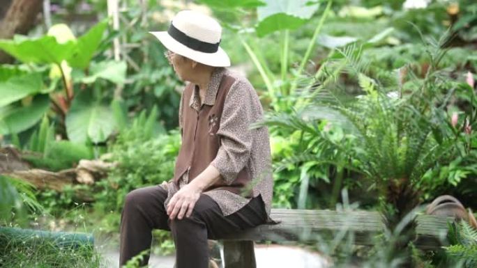 老年妇女坐在自然花园公园休息放松