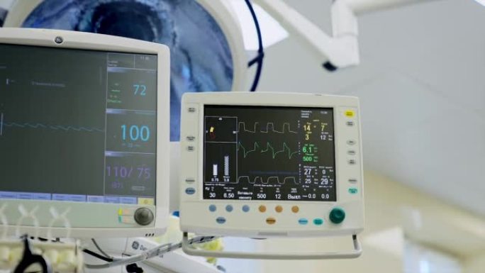操作过程中工作的屏幕越来越大。黑色监视器显示描绘手术患者生命迹象的线条和数字。