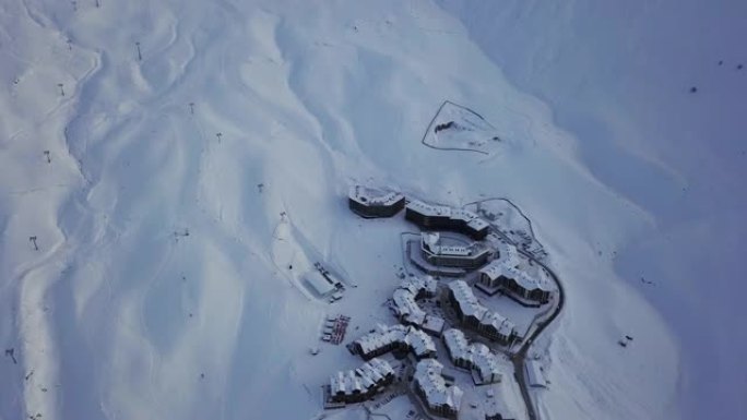 日落时分，沿着折返曲线路的山村小屋的鸟瞰图。日落时分有雪粉斜坡的滑雪胜地。佐治亚州新古达里。