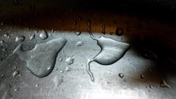 水滴的特写镜头缓慢地从金属表面流下。