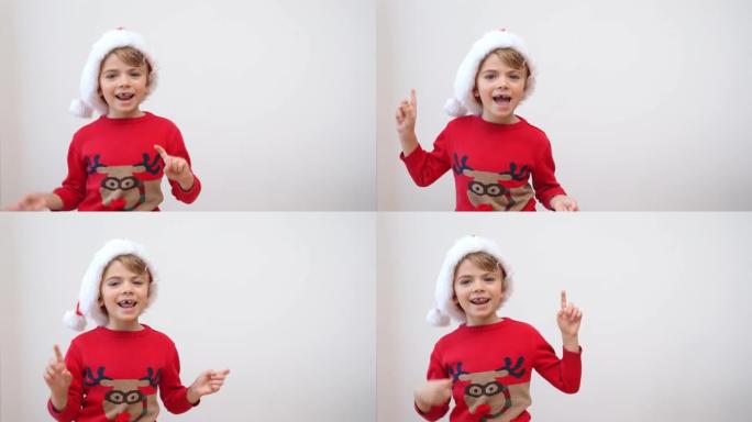 兴奋有趣的笑的小女孩戴着红色的圣诞老人帽子和圣诞驯鹿毛衣在白色背景下快乐地在镜头前跳舞。新年礼物购物