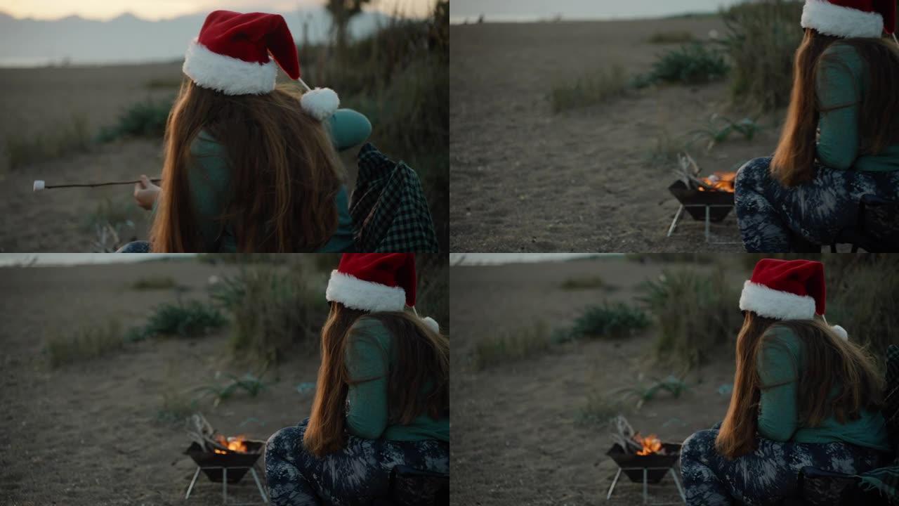 一个戴着新年红帽子的女孩，在海边的海滩上煎炸棉花糖。
