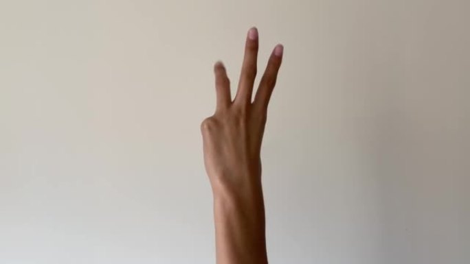 女人的手在白色背景上从一数到五。