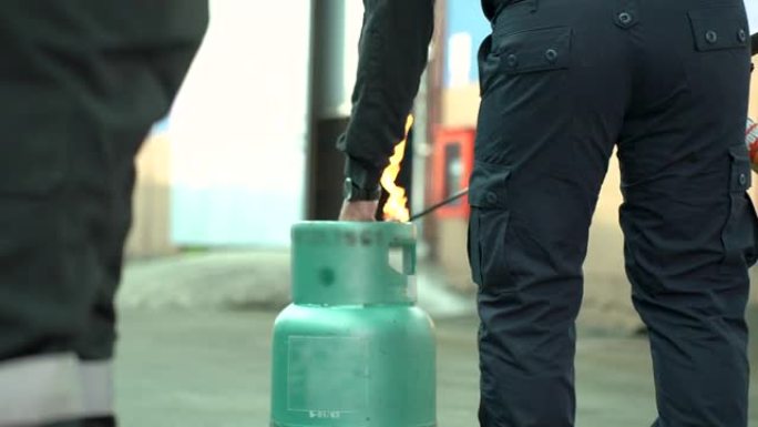 为了安全起见，男子教或培训如何使用二氧化碳 (CO2) 灭火器扑灭房屋或工业燃料中的火灾。