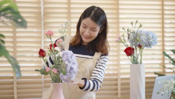 亚洲女性在花瓶中插花，并向在线朋友征求意见。