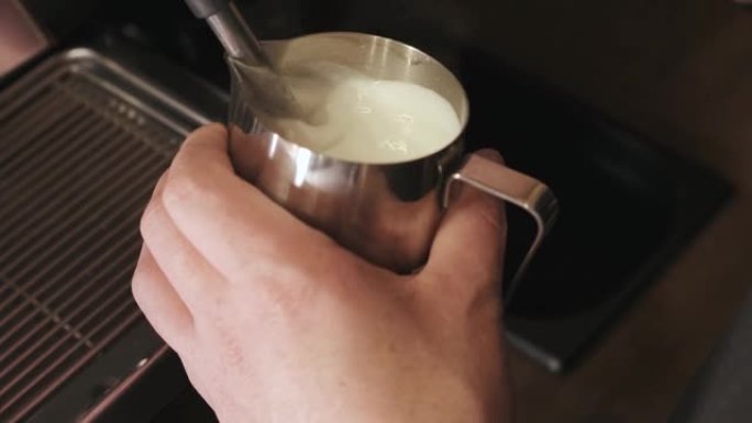 卡布奇诺的制备。咖啡师将热牛奶倒入一杯浓缩咖啡中