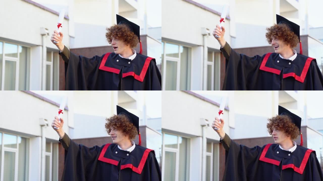 快乐凯旋男毕业生站在大学附近拿着文凭的低角度肖像
