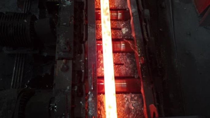 在冶金车间轧制过程中，铁水在辊子上移动。金属生产，将来自加热炉的炽热坯料轧制成机架。钢铁厂