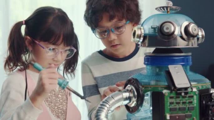 教育主题: 聪明的男生和女学生用回收材料制作机器人，机器人编程技术和儿童教育概念。
