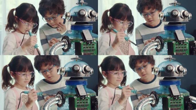 教育主题: 聪明的男生和女学生用回收材料制作机器人，机器人编程技术和儿童教育概念。