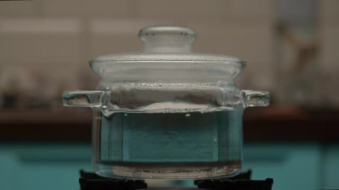 慢动作在透明锅中沸腾的水。厨房锅里的大水泡。