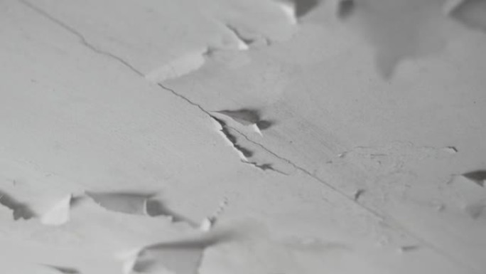 浴室天花板上白色油漆的开裂剥落层。损坏的破损干墙